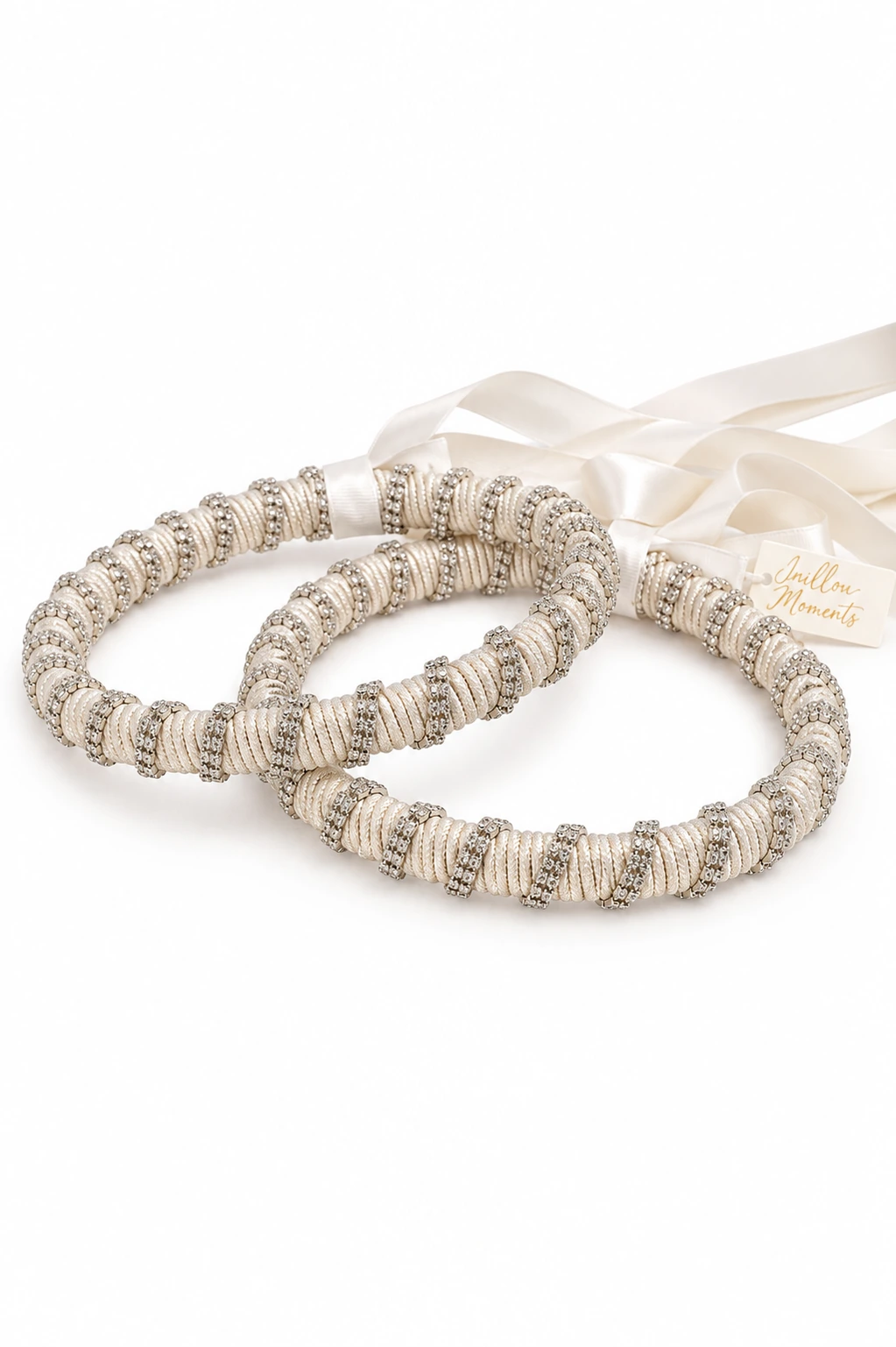 Χειροποίητα στέφανα γάμου σε ivory απόχρωση με λαμπερά στρας σε λευκό φόντο.